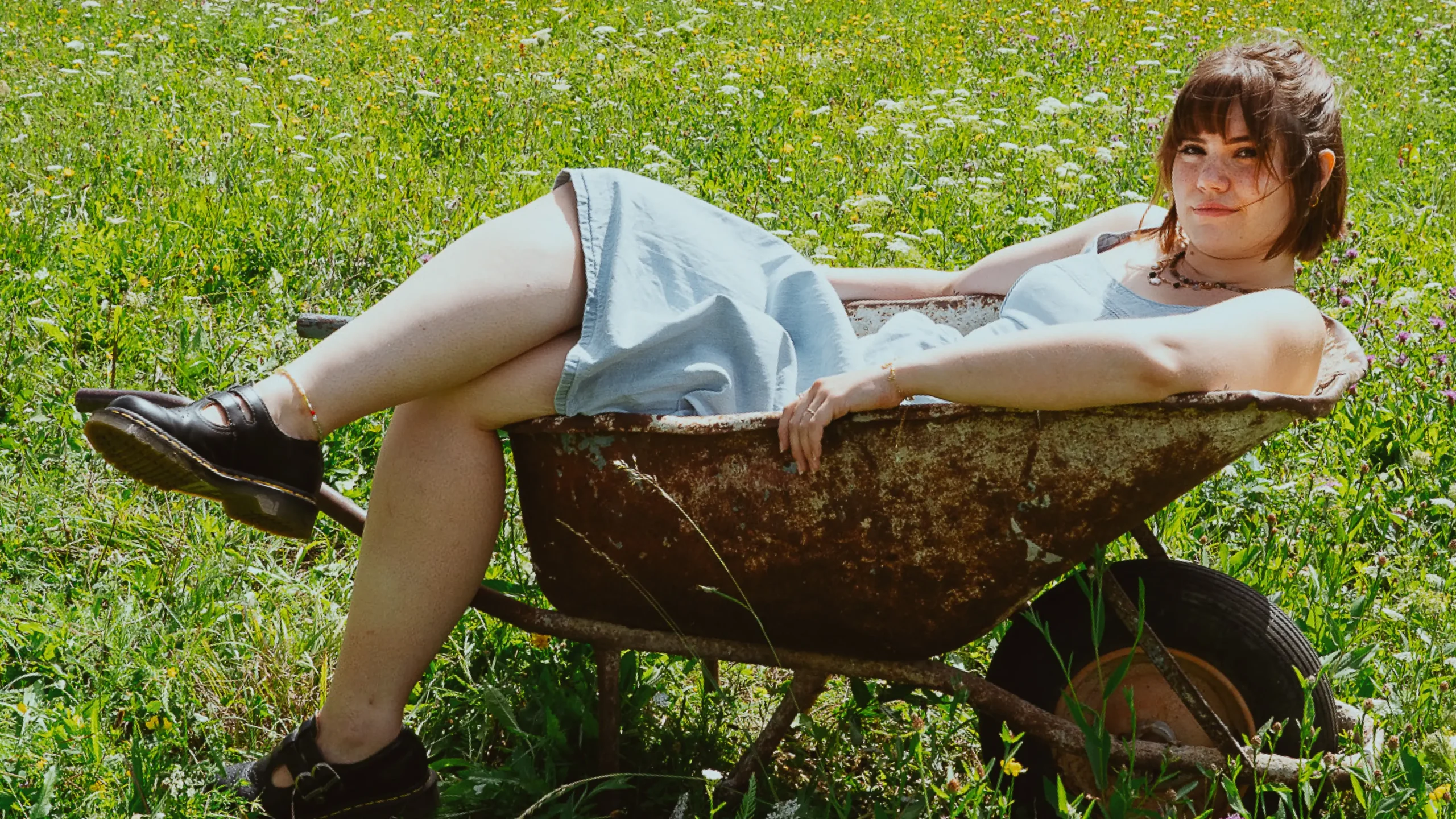 scheibtruhe-frau-garten-wiese-latzhose